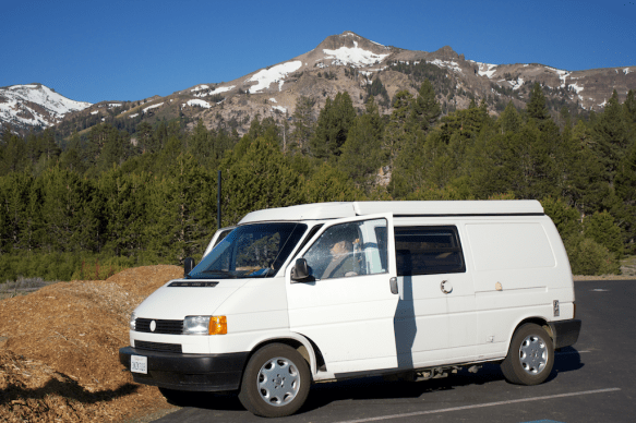 White eurovan camper van parked in front of mountains in the Sierra's. 