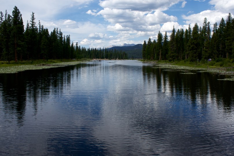 River with reflection of trees and clouds in the sky